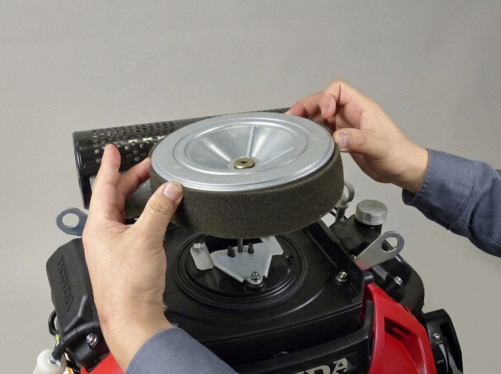 technician opening and removing air cleaner element from honda engine gx 630 660 690